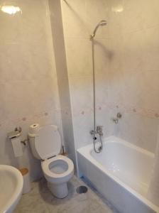 een badkamer met een toilet, een bad en een wastafel bij Acogedor apartamento céntrico in O Grove