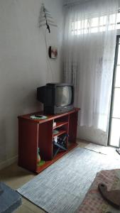 a tv sitting on a table in a living room at Casinha Aconchegante in Guarulhos