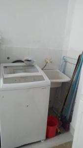 a kitchen with a sink and a white refrigerator at Casinha Aconchegante in Guarulhos