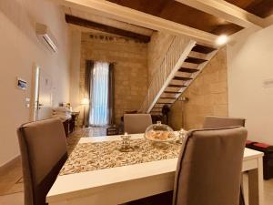 una sala da pranzo con tavolo e alcune sedie di Casa Cara a Birgu (Vittoriosa)