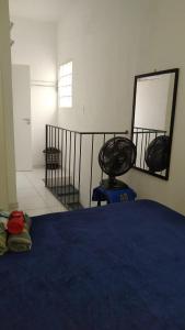 a bedroom with a blue bed and a mirror at Casinha Aconchegante in Guarulhos