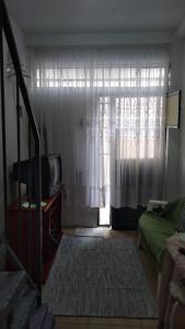 a living room with a television and a window at Casinha Aconchegante in Guarulhos