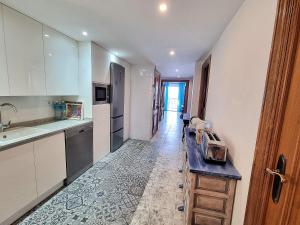 a kitchen with white cabinets and a counter top at Torre Hirta 1 in Peniscola
