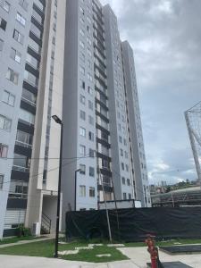 een hoog gebouw met een rode brandkraan ervoor bij Apartamento nuevo contiguo a estación de buses in Manizales