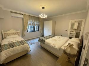 a bedroom with two beds and a chandelier at Fuays Villa Premium in Trabzon