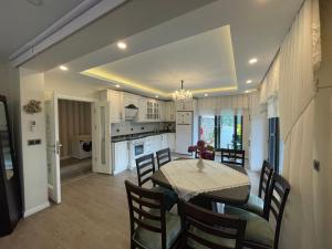 cocina y comedor con mesa y sillas en Fuays Villa Premium, en Trabzon