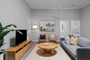 a living room with a couch and a tv at Haven on Hunter - 500m to Civic Theatre in Newcastle
