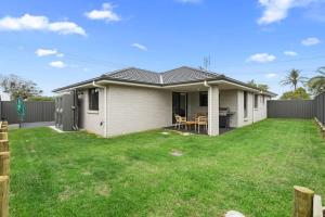 a small white house with a yard at Time Out - Beautifully decorated new home in Cessnock
