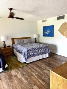 um quarto com uma cama com um cobertor azul e branco em IslandVista 1BR: Ocean & Golf Bliss em Kahana