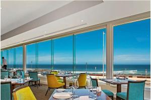 a restaurant with tables and chairs and a view of the ocean at Haven on Hunter - 500m to Civic Theatre in Newcastle