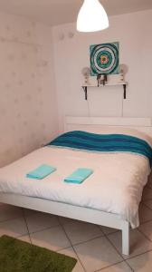 een wit bed met twee blauwe handdoeken erop bij Fortuna Apartmanok Eger in Eger