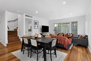 a living room with a table and a couch at Catch the Breeze - Pet Friendly Townhouse in Newcastle