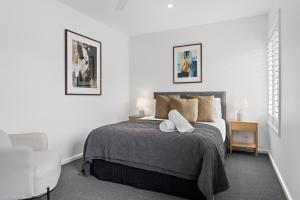 a bedroom with a bed with two pillows at Catch the Breeze - Pet Friendly Townhouse in Newcastle