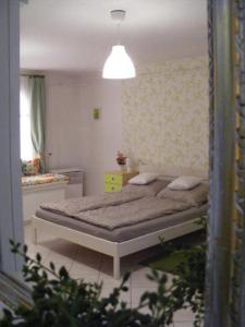 ein Schlafzimmer mit einem Bett und einer gelben Kommode in der Unterkunft Fortuna Apartmanok Eger in Eger