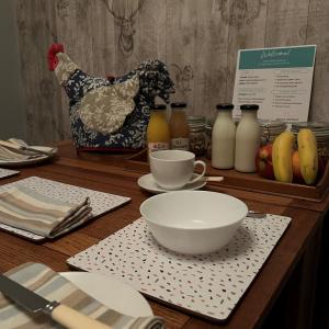 una mesa con un tazón y una taza de café y un pollo en Caistor Bed & Breakfast, en Caistor