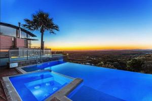 a swimming pool on top of a house with a sunset at Sea View Retreat in Nelson Bay