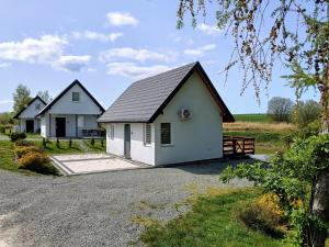 una casa bianca con il tetto nero di Domki Brzezówka nad stawami a Kłodzko