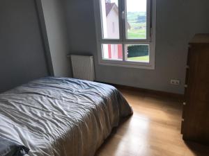 1 dormitorio con cama y ventana en El asturcón, en Candás