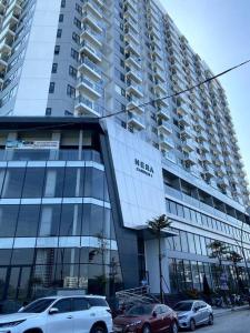 a large building with cars parked in front of it at Căn hộ 3 phòng ngủ từ 4-6 người, bể bơi, phòng gym, view thành phố in Thôn Văn Dương