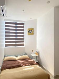 a bedroom with a bed and a window with blinds at Căn hộ 3 phòng ngủ từ 4-6 người, bể bơi, phòng gym, view thành phố in Thôn Văn Dương