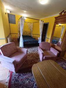 un soggiorno con 2 sedie e un letto di Chateau Montegut a Montégut