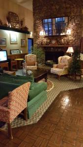 sala de estar con sofá verde y chimenea de piedra en Americourt Hotel - Mountain City, en Mountain City