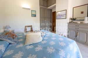 Un dormitorio con una cama azul con almohadas cubiertas de nieve en A12 - Villino semi-indipendente su tre lati, en Palau