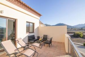 a patio with chairs and a table on a balcony at Ático dúplex La Calma - Llíber in Lliber