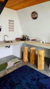 cocina con encimera y 2 taburetes de madera en Viewscape en Nuwara Eliya