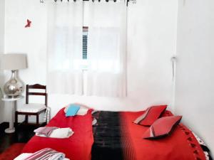 un divano rosso in una stanza con finestra di 3 bedrooms house with furnished garden and wifi at Encarnacao 1 km away from the beach a Encarnação