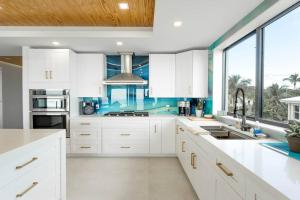 a kitchen with white cabinets and a large window at Tavernier Ocean Vista in Tavernier