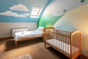 a childs room with two cribs and a painting of clouds at The Old Cart House in Westerdale