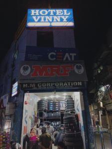 um sinal para um mercado de gatos vitaminados de hotel com pessoas do lado de fora em Hotel Vinny em Jalandhar
