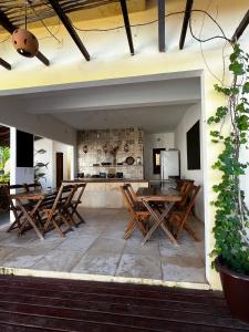 an outdoor patio with wooden tables and a kitchen at Pousada Villa Xaréu in Barra Grande