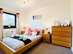 a bedroom with a bed with a dresser and a window at Beautiful & Spacious 2-Bed Flat in City Centre with Free Parking in Glasgow