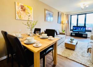 a living room with a dining room table with chairs at Beautiful & Spacious 2-Bed Flat in City Centre with Free Parking in Glasgow