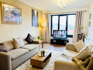 a living room with two couches and a tv at Beautiful & Spacious 2-Bed Flat in City Centre with Free Parking in Glasgow