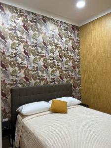 ナポリにあるB&B Caracciolo 109の花の壁のベッドルーム1室