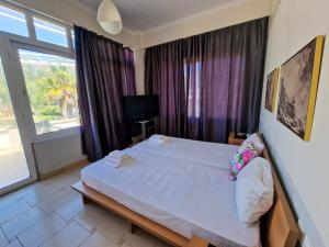 una camera da letto con un grande letto bianco e una finestra di Kalogria Beach Apartments a Kalogria