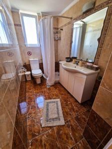 łazienka z wanną, umywalką i toaletą w obiekcie Kalogria Beach Apartments w mieście Kalogria