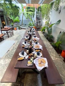 a long table filled with plates of food at Casa de Poço Guest House and Gallery in Mindelo