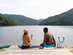 een man en vrouw op een steiger aan een meer bij Holiday Home Camping Sunélia La Source-1 by Interhome in Thérondels