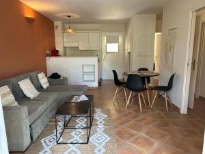 uma sala de estar com um sofá e uma mesa em Appartement Golf de Saumane 2 chambres 2 à 4 personnes em Saumane-de-Vaucluse