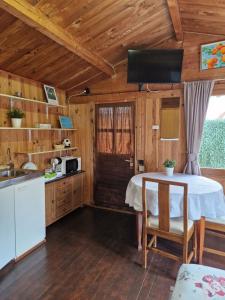 una cucina con tavolo in una cabina di legno di La casita de invitados a Denia