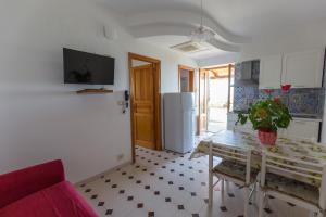 a kitchen with a table and a refrigerator at Case Vacanze Margherita in Lipari