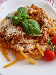 un plato blanco de pasta con queso y tomates en Wodnik, en Pisz