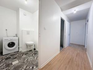 een badkamer met een wasmachine en een toilet bij Le Martray - Spacieux - Parking in Rennes