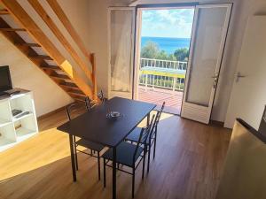 a dining room with a table and chairs and a large window at Apartment Le Télémaque 2 pièces Mezzanine by Interhome in Conca