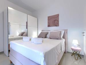 Dormitorio blanco con cama blanca grande y espejo en Apartment Villa Amra-1 by Interhome, en Poreč