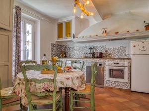 een keuken met een tafel met stoelen en een fornuis bij Holiday Home La Bastide de Magdeleine by Interhome in Laouque